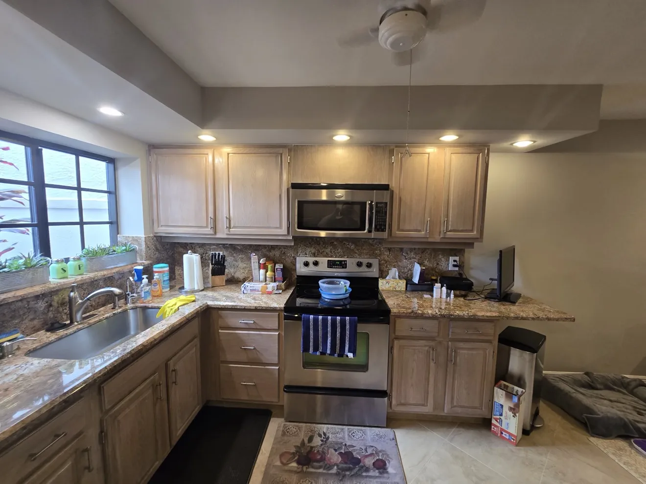 Kitchen with original cabinets, stove, and sink before demolition by Superior Demo & Debris Removal in Broward County FL